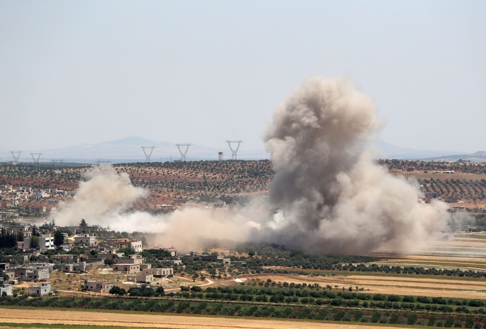 Smoke billows during reported Syrian government forces' bombardments on the village of Sheikh Mustafa in the southern countryside of the militant-held Idlib province on Monday. — AFP