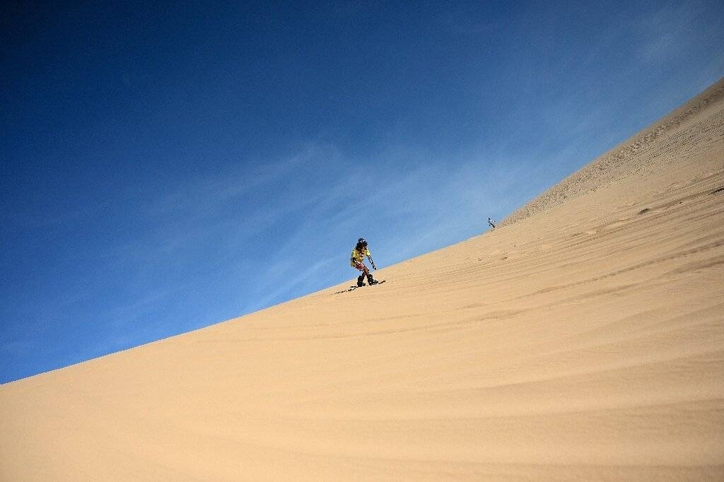Sun-kissed and shaggy haired, Nguyen Thai Binh swaps his flip flops for bulky boots ahead of snowboarding practice on the sand dunes of southern Vietnam—the unlikely training ground for the country's fledgling winter athletes. — AFP