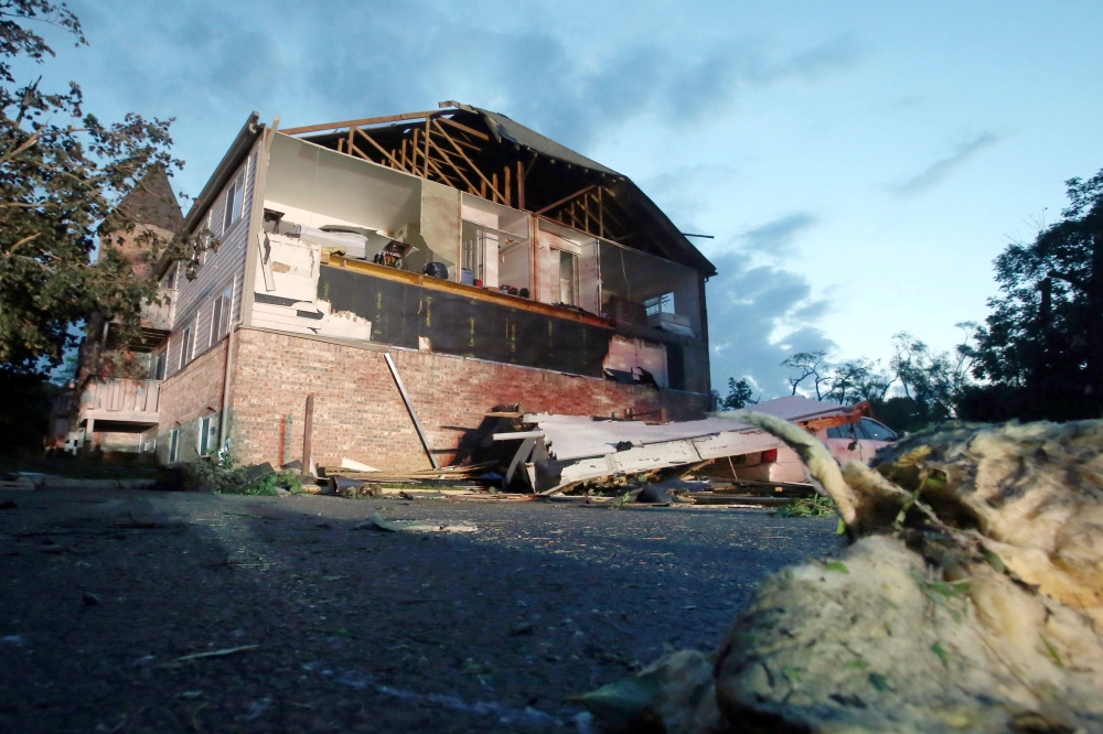 A car and truck sit under a fallen tree the morning after a tornado touched down overnight in Trotwood near Dayton, Ohio, US, on Tuesday. — Reuters