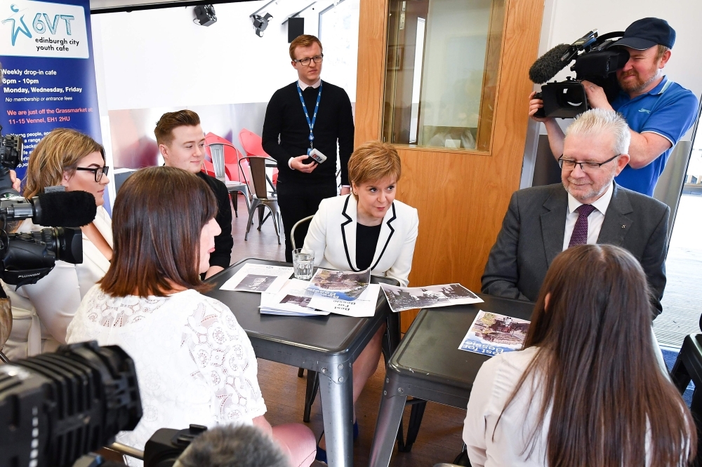 First Minister of Scotland and Scottish National Party (SNP) leader, Nicola Sturgeon (C) and Constitutional Relations Secretary, Michael Russell (R) meet members of the 6VT Edinburgh City Youth Cafe in Edinburgh on Wednesday, as the First Minister promotes the Referendums (Scotland) Bill and young voter engagement.  The visit coincides with the publication of the Referendums (Scotland) Bill, a legislation paving the way for a new referendum on Scottish independence. — AFP