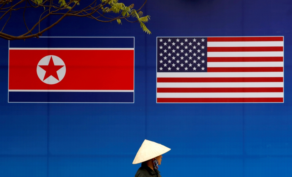 A person walks past a banner showing North Korean and US flags ahead of the North Korea-US summit in Hanoi, Vietnam, in this file photo. — Reuters