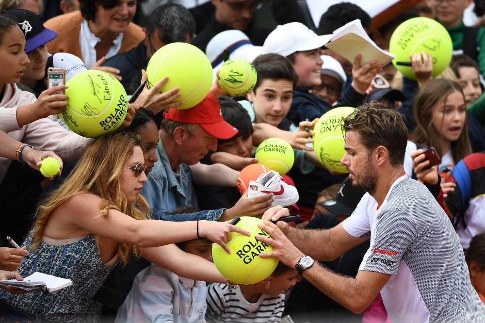 Switzerland's Stanislas Wawrinka poses for a selfie picture with a fan at the end of his men's singles second round match against Chile's Christian Garin on day four of The Roland Garros 2019 French Open tennis tournament in Paris on Wednesday. — AFP