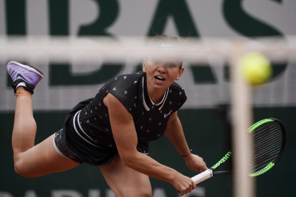 Romania's Simona Halep eyes the ball as she plays against Poland's Magda Linette during their men's singles second round match on day five of The Roland Garros 2019 French Open tennis tournament in Paris on Thursday. — AFP 
