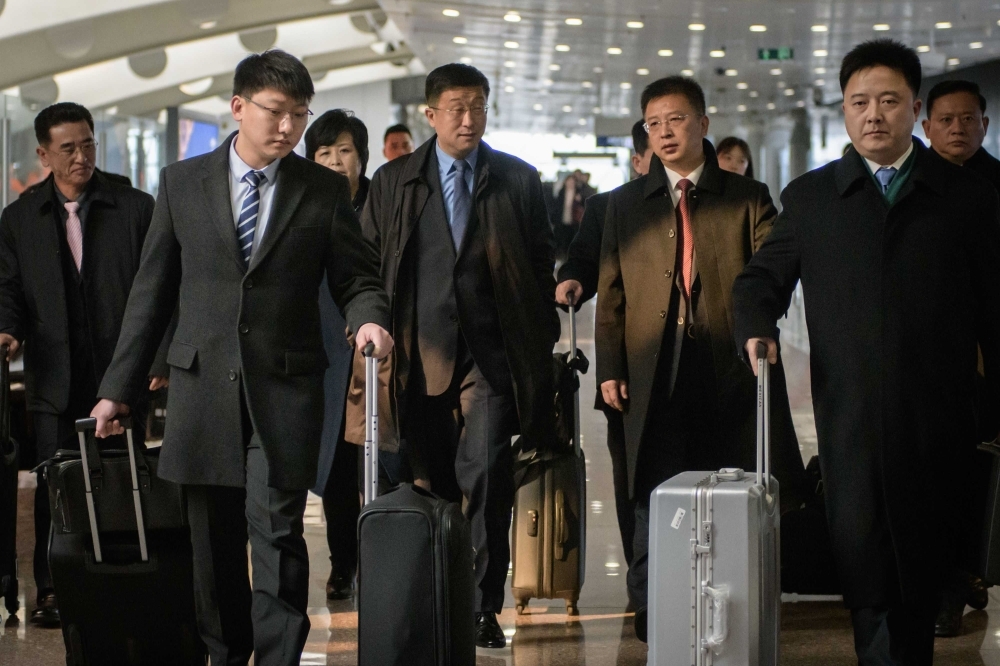 A man believed to be North Korean negotiator Kim Hyok Chol, center L-blue tie, after arriving on an Air Koryo flight from Pyongyang, at Beijing international airport, in this Feb. 19, 2019 file photo. — AFP