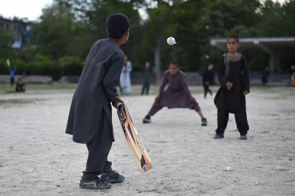 In this photo taken on May 19, 2019, Afghan children play cricket in a field in Kabul. Afghanistan caught the cricket bug thanks largely to a new generation growing up in refugee camps in cricket-obsessed Pakistan and the country has secured their place in the Cricket World Cup.  — AFP