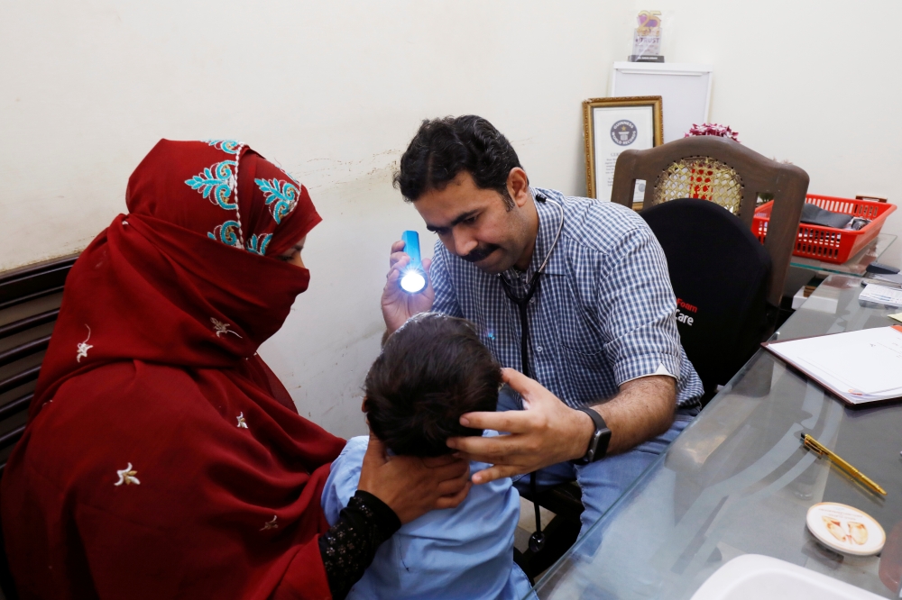 A medical worker helps a woman to draw blood for a HIV test at the free medical camp in Ratodero, Pakistan, in this May 25, 2019 file photo. — Reuters