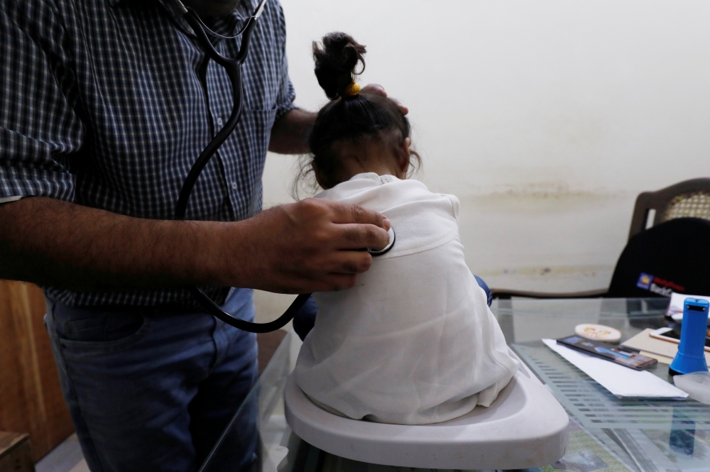 A medical worker helps a woman to draw blood for a HIV test at the free medical camp in Ratodero, Pakistan, in this May 25, 2019 file photo. — Reuters