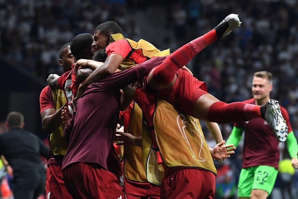 Liverpool's Belgian forward Divock Origi (L) celebrates with teammates after scoring his team's second goal during the UEFA Champions League final football match between Liverpool and Tottenham Hotspur at the Wanda Metropolitano Stadium in Madrid on Saturday. — AFP
