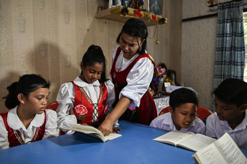 Students dressed in traditional Portuguese outfits dance before learning the Kristang language at the Portuguese Settlement in Ujong Pasir, Malacca, in this May 11, 2019 file photo. — AFP