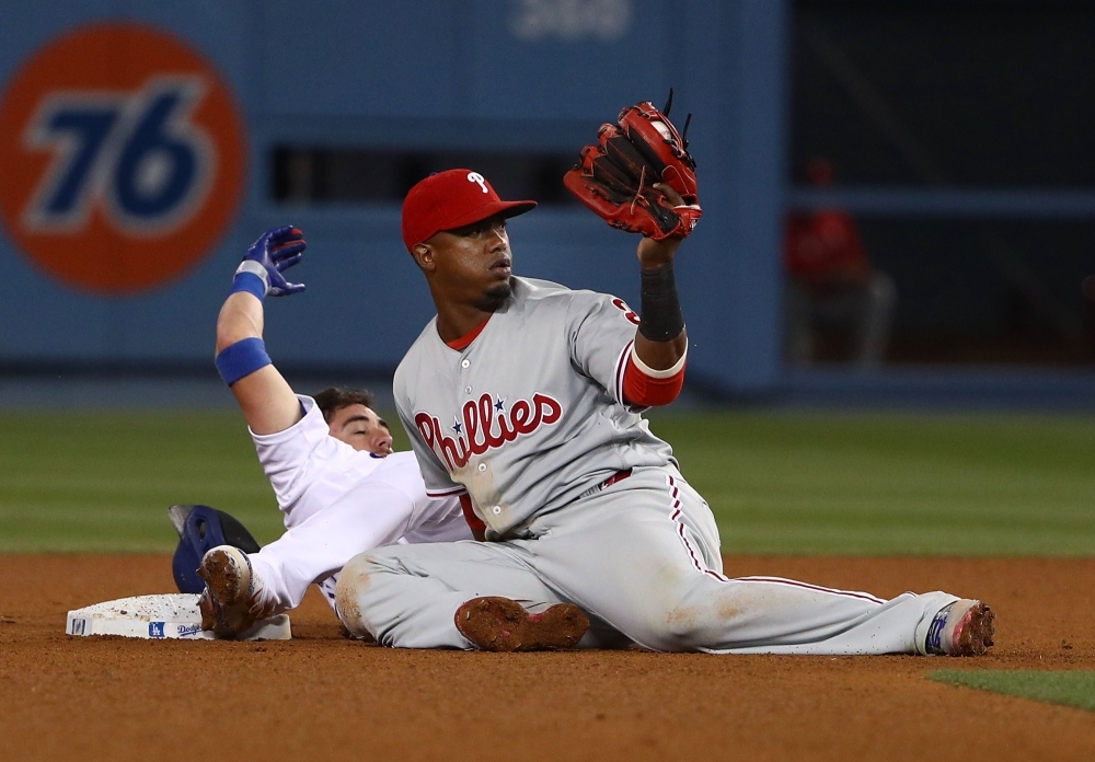 Jean Segura No. 2 of the Philadelphia Phillies holds up his glove to the second base umpire after tagging Cody Bellinger No. 35 of the Los Angeles Dodgers at second base in the eighth inning of the MLB game at Dodger Stadium on June 01, 2019 in Los Angeles, California. The Dodgers defeated the Phillies 4-3. — AFP