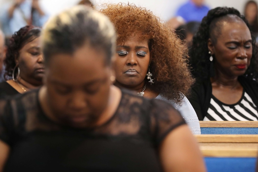 Worshipers pray during a memorial service for the 12 victims of a mass shooting at Piney Grove Baptist Church in Virginia Beach, Virginia, on Sunday. — AFP