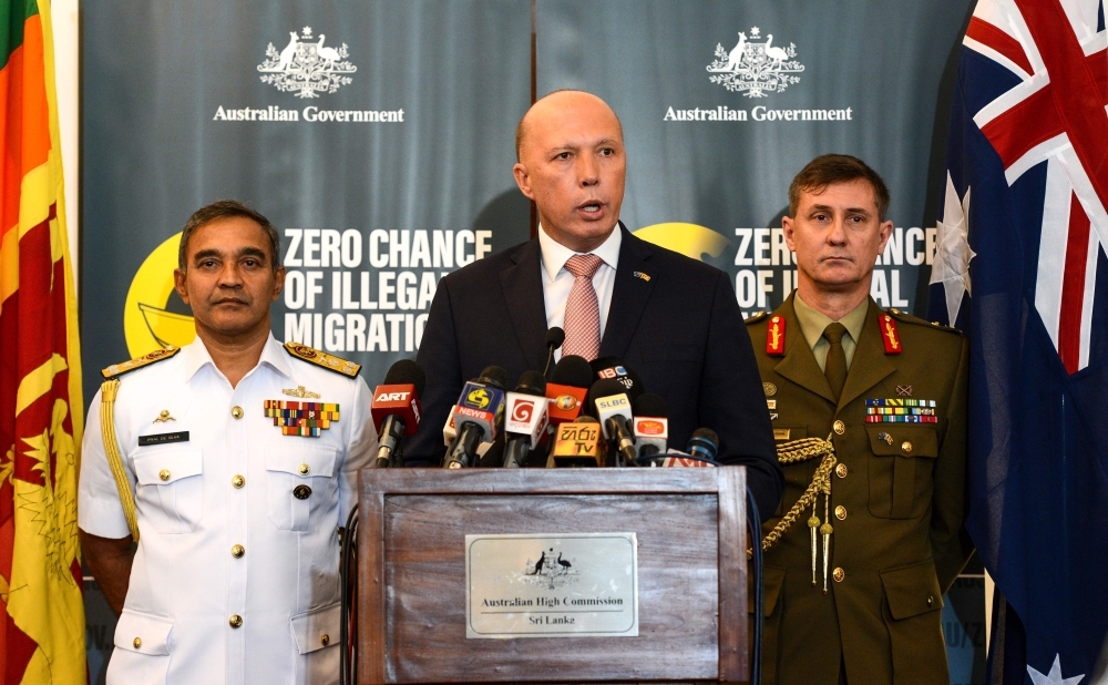 Australia's Home Minister Peter Dutton (C) speaks to the media as Sri Lanka's navy commander Piyal De Silva (L), and the head of Australia's Operation Sovereign Borders Major General Craig Furini (R) look on in Colombo on Tuesday. — AFP