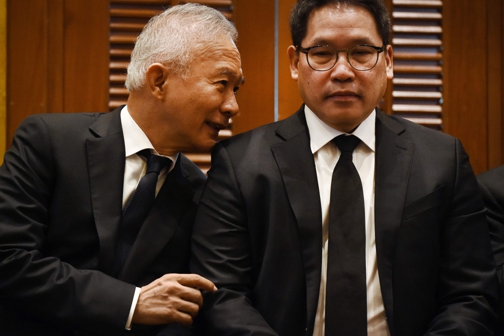 Chartpattana Party leader Suwat Liptapanlop (L) speaks to Palang Pracharath Party leader Uttama Savanayana during a joint press conference between pro-junta parties endorsing Prayut Chan-O-Cha for the position of prime minister of Thailand, in Bangkok on Tuesday. — AFP