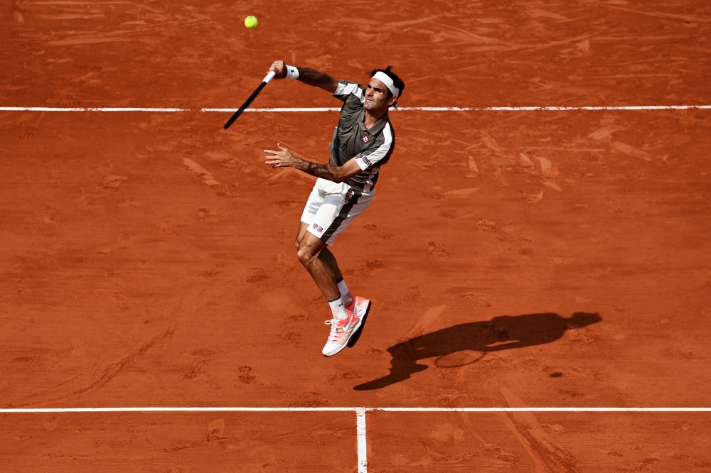  Switzerland's Roger Federer serves the ball to Switzerland's Stanislas Wawrinka during their men's singles quarter-final match on day ten of The Roland Garros 2019 French Open tennis tournament in Paris on Tuesday. — AFP