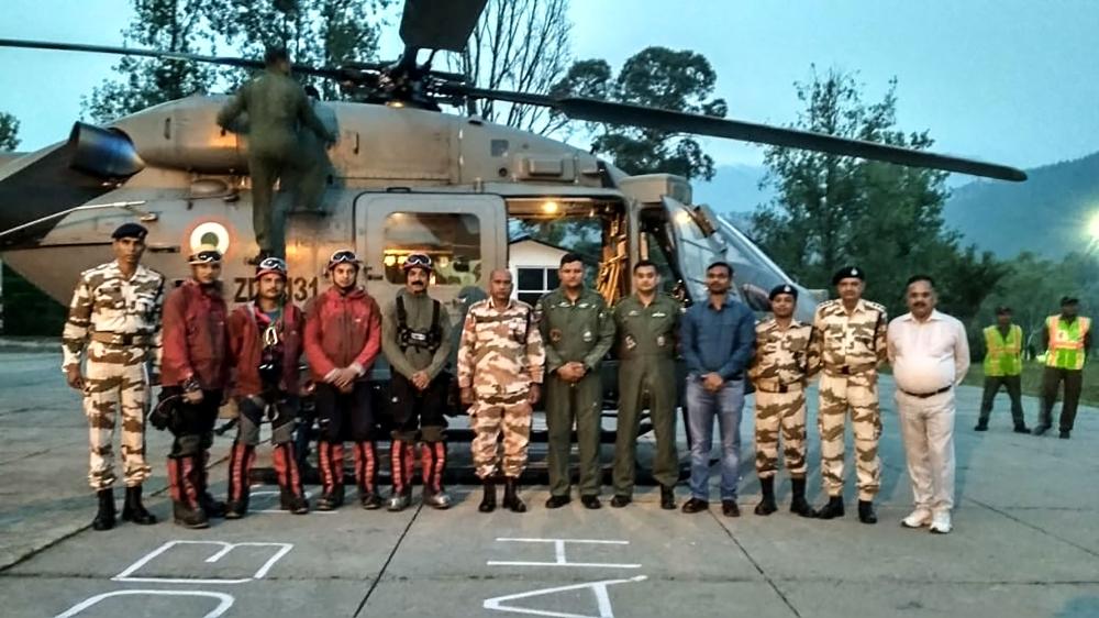 In this handout photo released by the Indo-Tibetan Border Police (ITBP) on Tuesday, the rescue mission team composed of ITPB trained mountaineers and Air Force personnel poses for photographs at the Pithoragarh helipad in the Indian state of Uttarakhand, before going to retrieve the bodies of climbers. — AFP