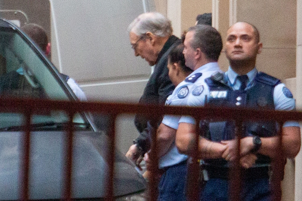 Jailed Australian Cardinal George Pell is escorted to a white van as he leaves Victoria State's Supreme Court in Melbourne on Wednesday. — AFP