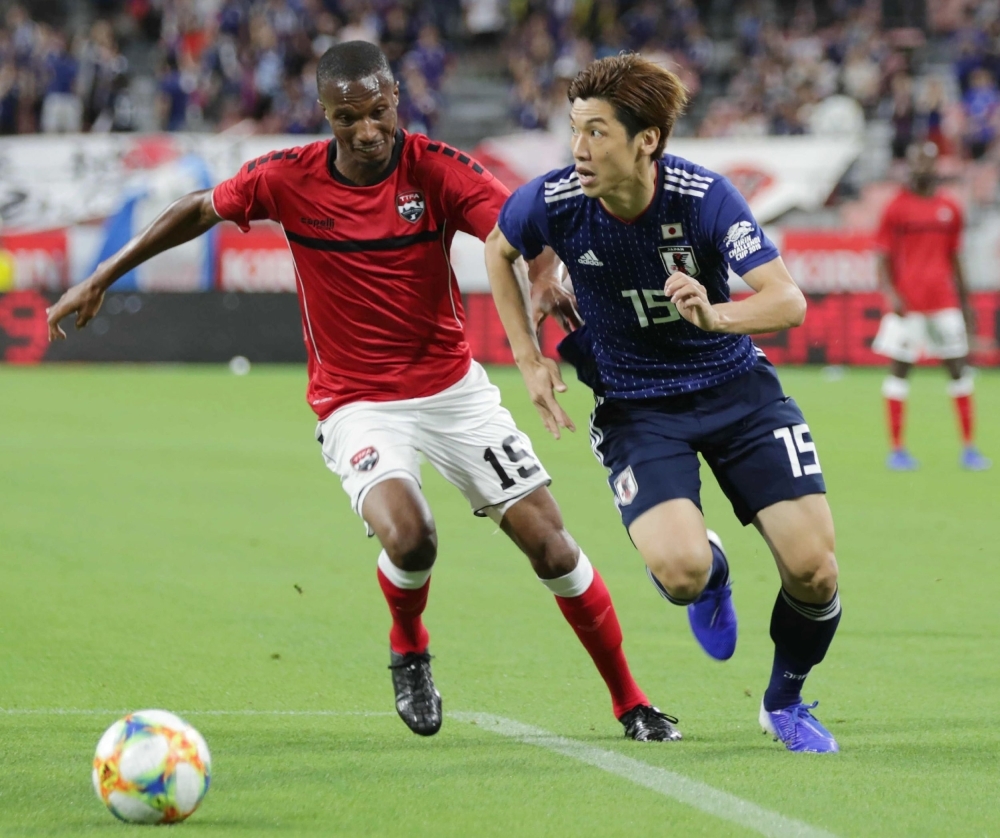 Trinidad and Tobago's midfielder Kevan George, left, and Japan's forward Yuya Osako compete for the ball during their friendly football match at Toyota Stadium, Aichi prefecture, on Wednesday. — AFP