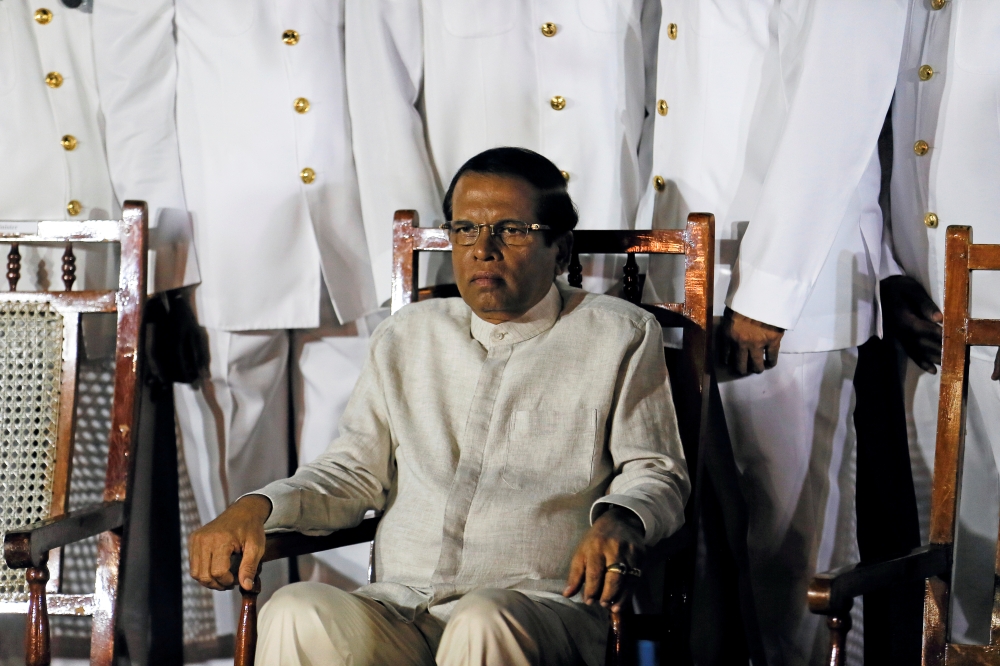 Sri Lanka's President Maithripala Sirisena waits next to Navy officers for a group photo during a commissioning handover ceremony of the P 626 ship by US at the main port in Colombo on Thursday. — Reuters