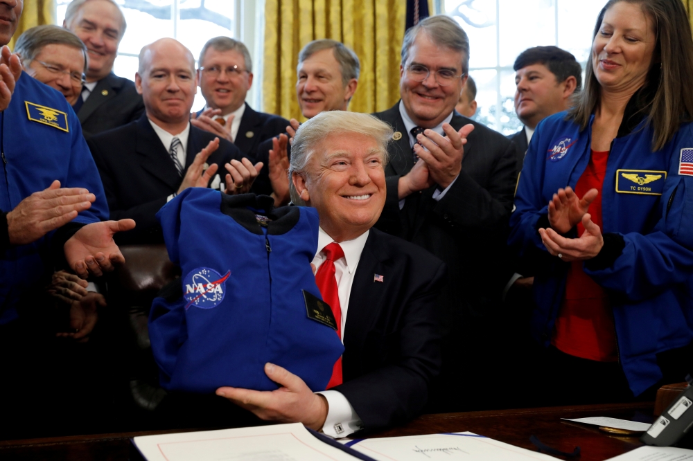 US President Donald Trump receives a NASA jacket during a signing ceremony for S442, the NASA transition authorization act, in the Oval Office of the White House in Washington, US, March 21, 2017, in this file photo. — Reuters