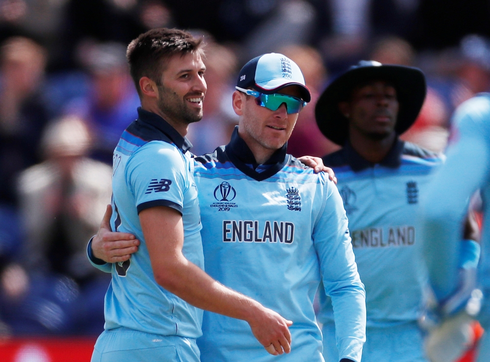 England's Mark Wood and Eoin Morgan celebrate taking the wicket of Bangladesh's Tamim Iqbal during the ICC Cricket World Cup match at the Cardiff Wales Stadium, Cardiff, Britain, on Saturday. — Reuters