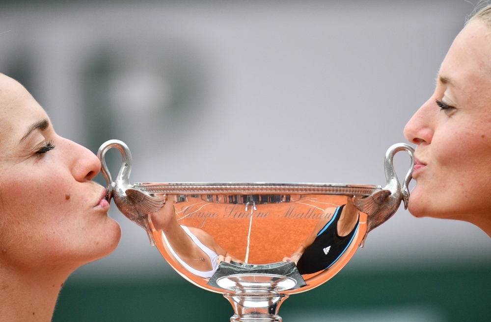 France's Kristina Mladenovic (R) and Hungary's Timea Babos kiss the Simone Mathieu Cup after winning against China's Duan Ying-Ying and China's Zheng Saisai in the women's doubles final match, on day fifteen of The Roland Garros 2019 French Open tennis tournament in Paris on Sunday. — AFP