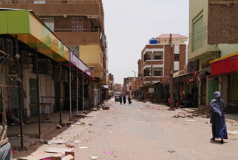 A Sudanese woman walks past closed shops in a commercial street in Khartoum's twin city Omdurman on the first day of a civil disobedience campaign across Sudan on Sunday. — AFP