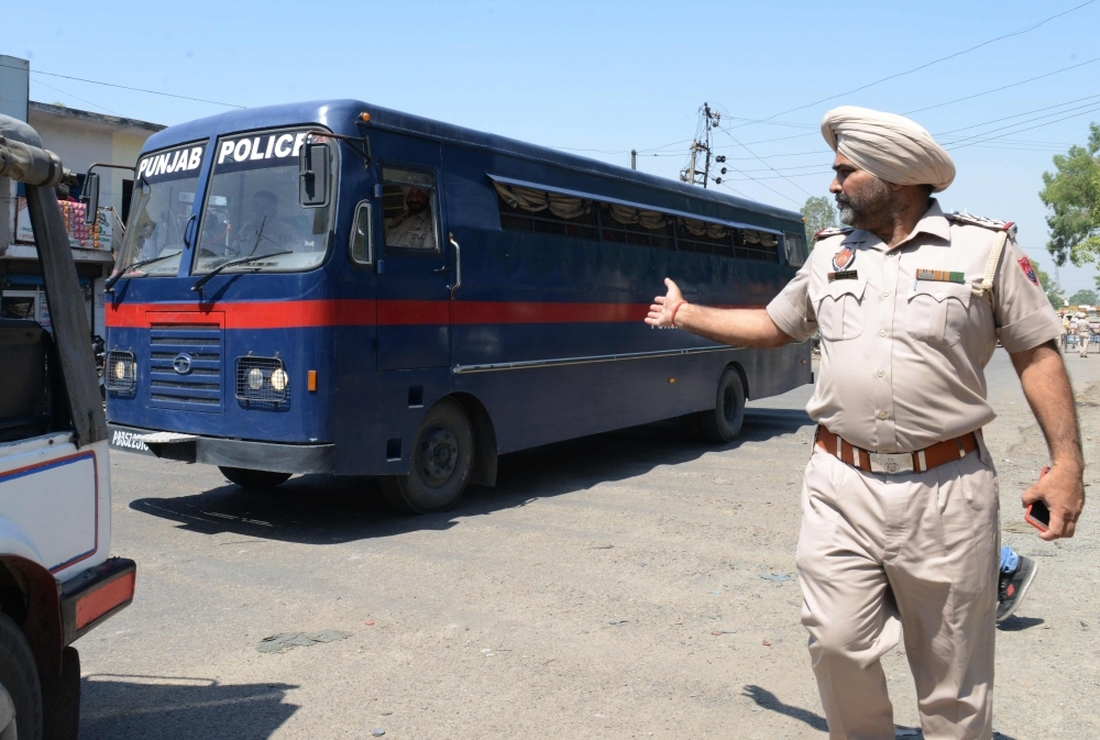 Indian Punjab Police personnel escort a police vehicle carrying the seven accused for the rape and murder of an eight-year-old nomadic girl in Kathua in Jammu and Kashmir. — AFP