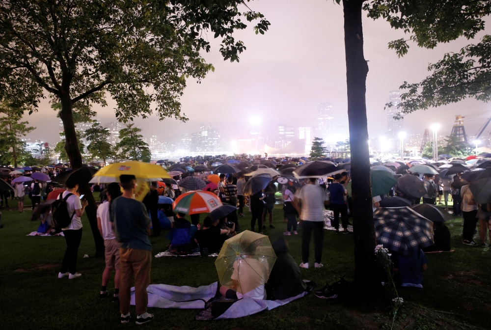 People stand outside the Legislative Council building as they protest the extradition bill with China in Hong Kong, China, on Tuesday. — Reuters