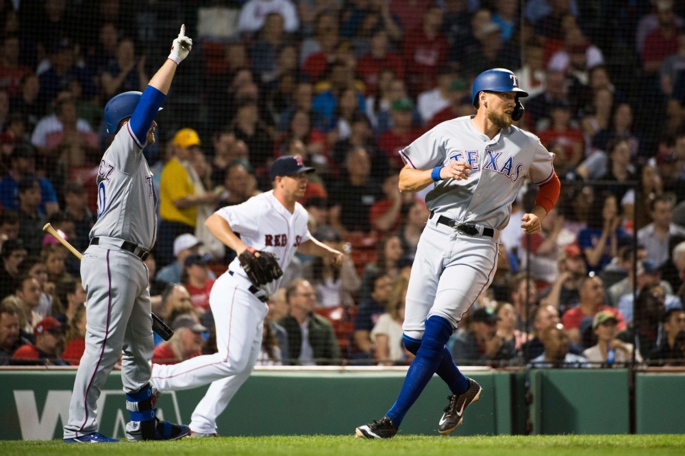 Tim Federowicz No. 50 celebrates as teammate Hunter Pence No. 24 of the Texas Rangers scores in the fifth inning against the Boston Red Sox at Fenway Park on Wednesday in Boston, Massachusetts. — AFP