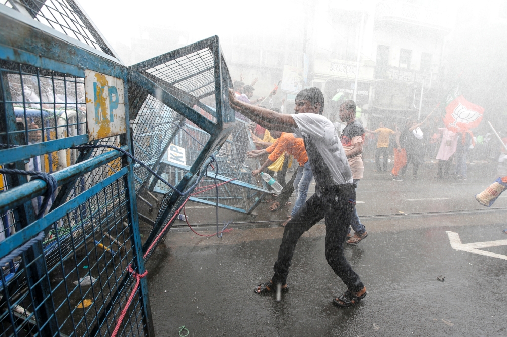 Supporters of India’s Bharatiya Janata Party (BJP) break barricades as police use water cannon to disperse them during a protest against what they call violence against their party workers in the state of West Bengal, in Kolkata, India, on Wednesday. — Reuters
