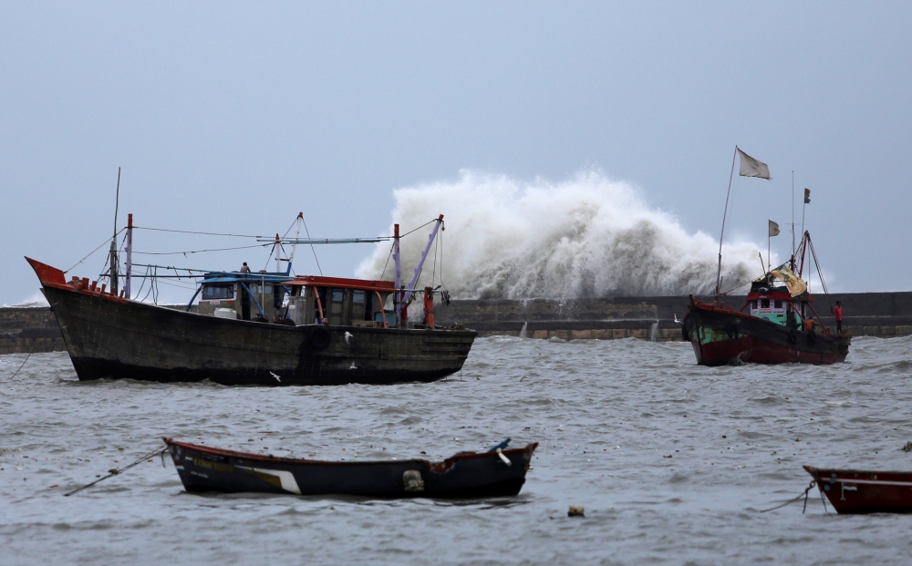 Waves crash against the jetty at a fishing harbor ahead of the expected landfall of Cyclone Vayu at Veraval, India, Wednesday. — Reuters