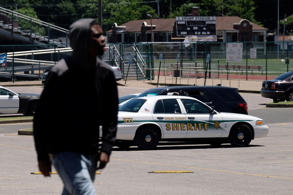 A young man walks in front of a police patrol parked in front of a high school a day after violent clashes between police and protesters broke out on streets overnight in Memphis, Tennessee, US, Thursday. — Reuters