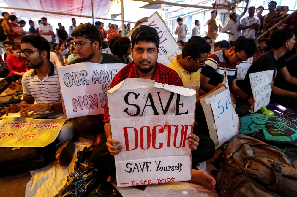 A doctor holds a placard at a government hospital during a strike demanding security after the recent assaults on doctors by the patients' relatives, in Kolkata, India,  Friday. — Reuters