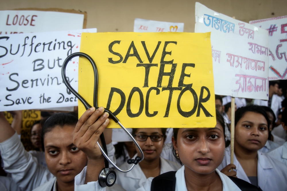 A doctor holds a placard at a government hospital during a strike demanding security after the recent assaults on doctors by the patients' relatives, in Kolkata, India,  Friday. — Reuters