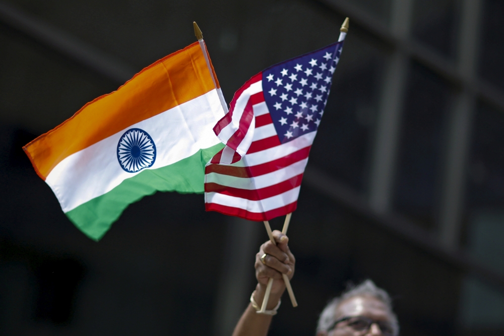 A man holds the flags of India and the US while people take part in the 35th India Day Parade in New York in this August 16, 2015, file photo. — Reuters