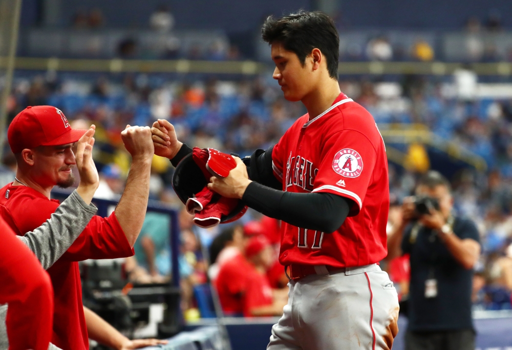 Los Angeles Angels designated hitter Shohei Ohtani (17) is congratulated by teammates in the dugout after a single during the seventh inning to hit for the cycle against the Tampa Bay Rays at Tropicana Field. — Reuters