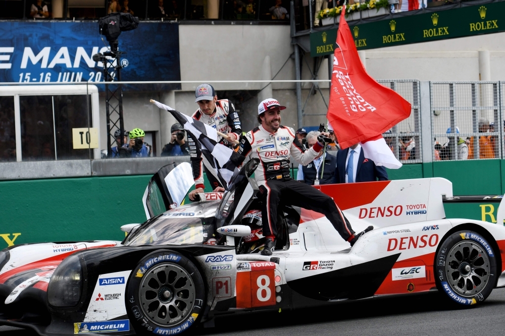 Toyota TS050 Hybrid LMP1 of Japanese's driver Kazuki Nakajima (R) Spain's driver Fernando Alonso (2L) and Switzerland's driver Sebastien Buemi (2R) celebrates on podium after winning in the 87th edition of the 24 Hours Le Mans endurance race on Sunday, at Le Mans northwestern France. — AFP 