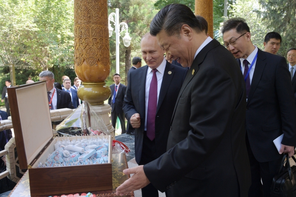 Russian President Vladimir Putin, left, and Chinese President Xi Jinping, right, look at ice creams before the fifth regular foreign ministers' meeting of the Conference on Interaction and Confidence Building Measures in Asia (CICA) at the Diaoyutai State Guesthouse in Dushanbe on Saturday. — AFP