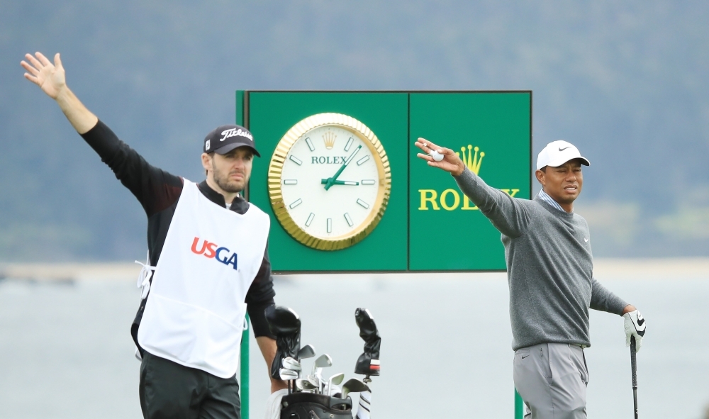 Tiger Woods of the United States reacts to his shot from the 18th tee as caddie for Byeong-Hun An of Korea, Daniel Parratt, looks on during the third round of the 2019 US Open at Pebble Beach Golf Links on Saturday in Pebble Beach, California. — AFP