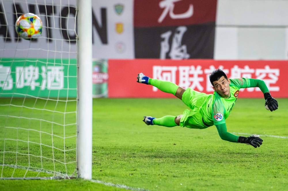 Wei Shihao (C) of Guangzhou Evergrande competes for the ball against Shandong Luneng players during their AFC Champions League Round of 16 football match in Guangzhou in China's southern Guangdong province on Tuesday. — AFP