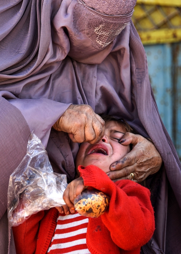 In this photo taken on March 20, 2019, an Afghan health worker administers a polio vaccine to a child in Kandahar province's Arghandab district. — AFP