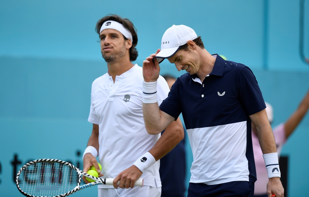 Britain's Andy Murray returns to Colombia's Juan Sebastian Cabal and Robert Farah during a first round doubles match at the ATP Fever-Tree Championships tennis tournament at Queen's Club in west London on Thursday. — AFP