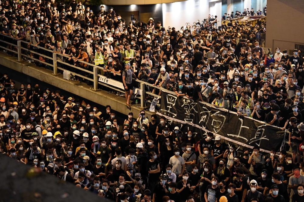 Protesters gather outside the police headquarters in Hong Kong on Friday. — AFP