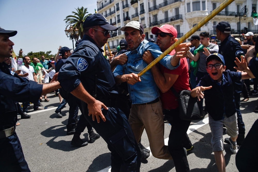 Algerian protesters scuffle with members of the security forces during the weekly Friday demonstration in the capital Algiers. — AFP