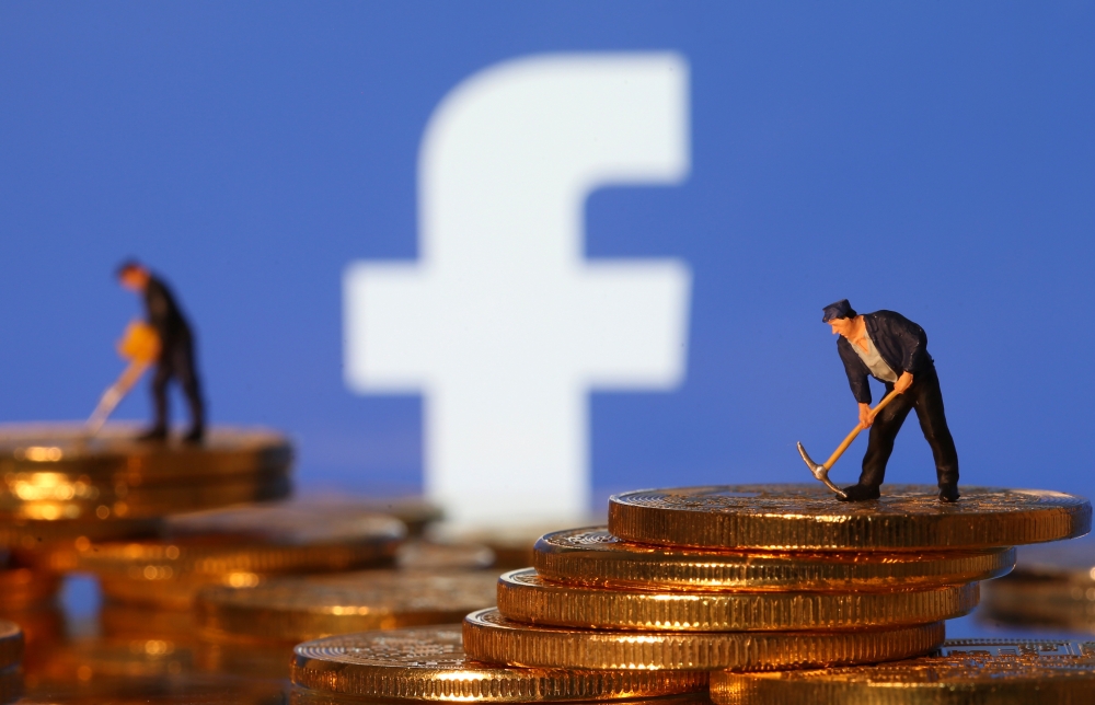 Small toy figures stand on representations of virtual currency in front of the Facebook logo in this illustration picture, June 21, 2019. — Reuters