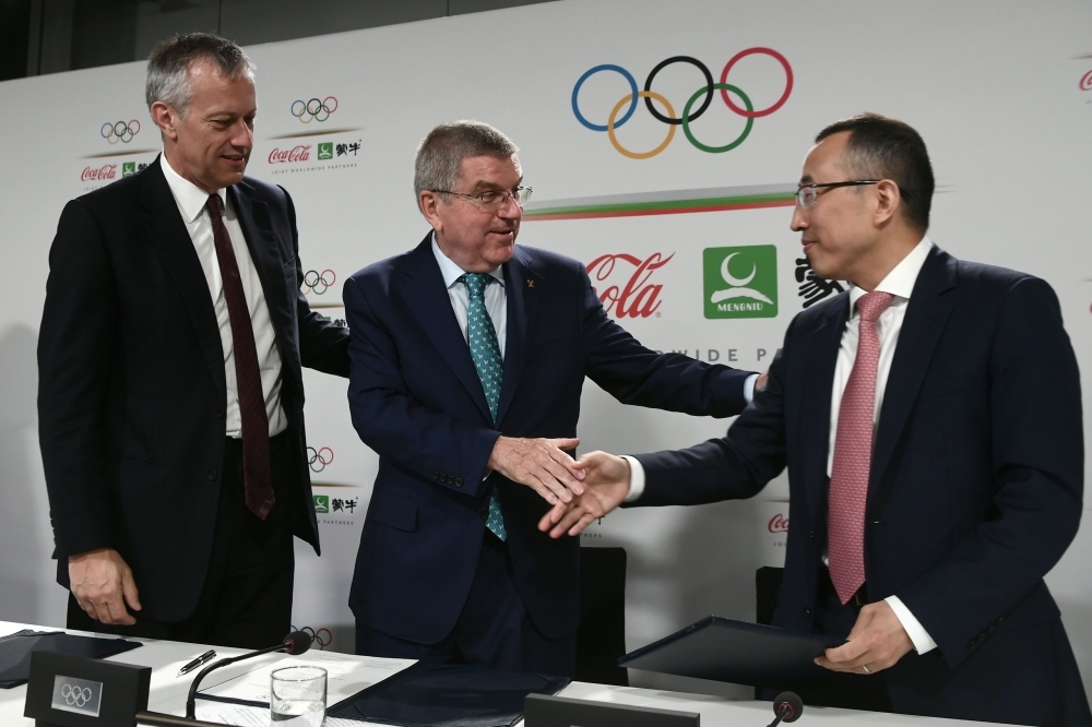 International Olympic Committee (IOC) president Thomas Bach (C), Coca-Cola President and CEO James Quincey (L) and China Mengniu Dairy CEO and Executive Director Jeffrey Minfang pose for photos during a press conference as part of the 134th Session of the International Olympic Committee (IOC) at the SwissTech Convention Centre in Lausanne, on Monday. — AFP