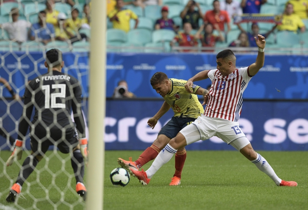 Colombia's Gustavo Cuellar (C) strikes to score past Paraguay's goalkeeper Roberto Fernandez (L) and defender Junior Alonso during their Copa America football tournament group match at the Fonte Nova Arena in Salvador, Brazil, on Sunday. — AFP