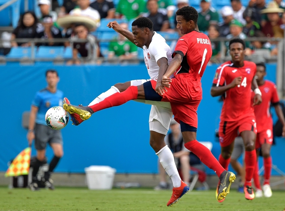 Canada's Lucas Cavallini (C) celebrates after scoring a goal on Cuba's Sandy Sanchez (R) as Yosel Piedra (L) looks on during their CONCACAF Gold Cup group stage football match at Bank of America Stadium in Charlotte, North Carolina, on Sunday. — AFP