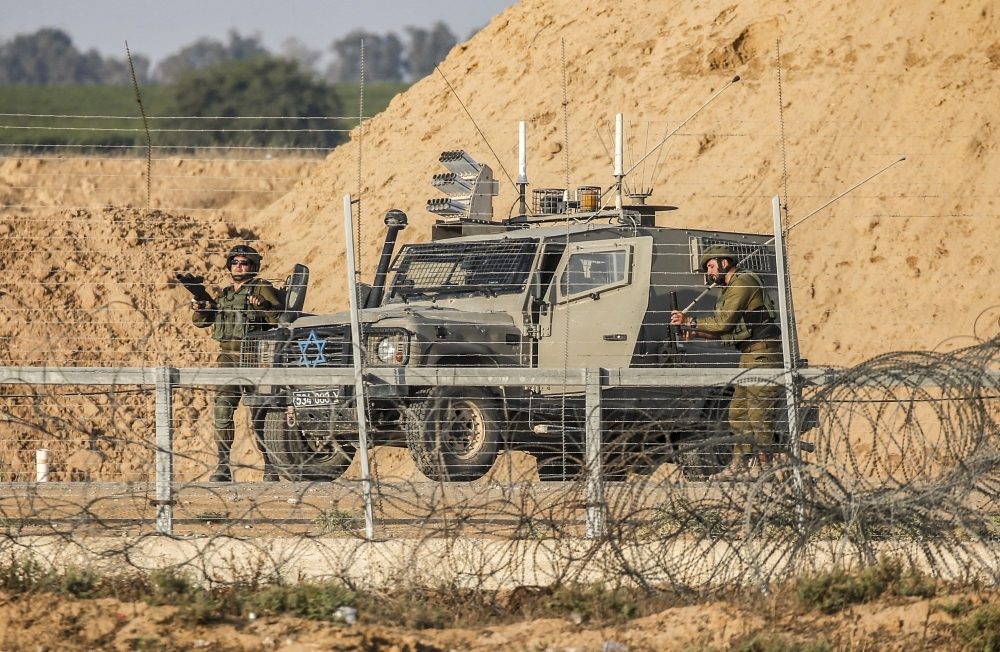 Israeli soldiers are seen next to a military vehicle across the barbed-wire border fence with the Gaza Strip during clashes following a Palestinian demonstration east of Khan Yunis, in this file photo. — AFP