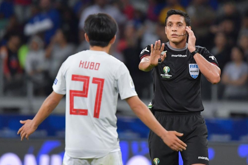 Venezuelan referee Jesus Valenzuela consults the VAR before disallowing a goal by Japan's Takefusa Kubo (L) during the Copa America football tournament group match against Ecuador at the Mineirao Stadium in Belo Horizonte, Brazil, on Monday. — AFP